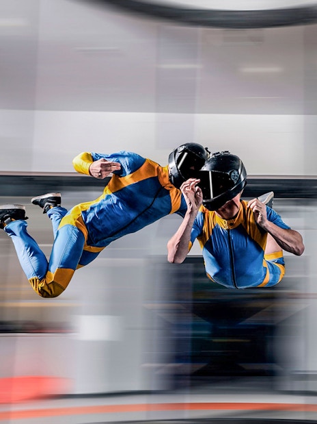 Indoor skydiving experience in Dubai with two people in flight suits.