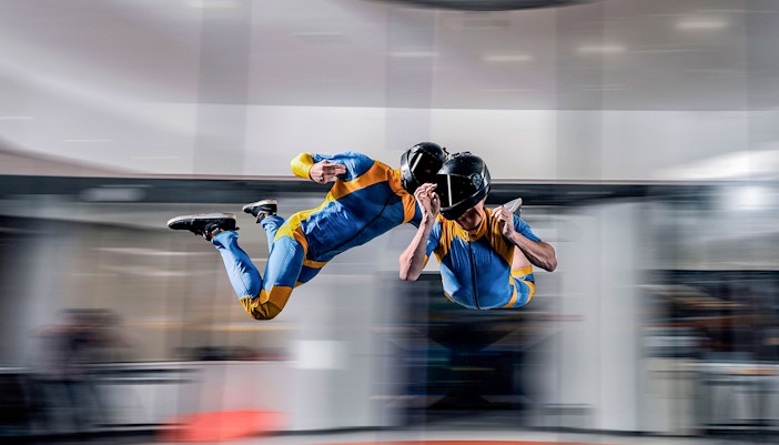 Indoor skydiving experience in Dubai with two people in flight suits.