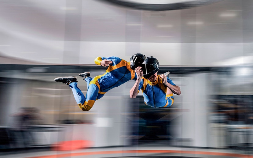 Indoor skydiving experience in Dubai with two people in flight suits.