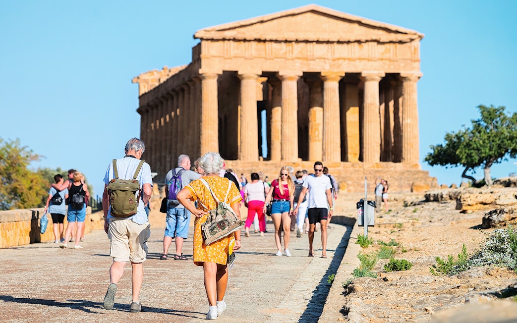 Tourists walking towards the Temple of Concordia in Agrigento during a minivan tour.
