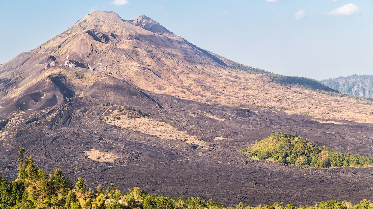 Mount Batur's volcanic landscape with lush greenery and crater lake in Bali, Indonesia.