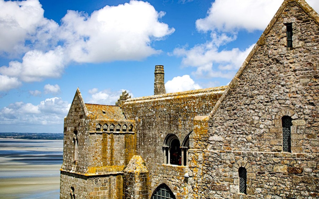 Mont-Saint-Michel Abbey stone architecture with coastal view in Normandy, France.