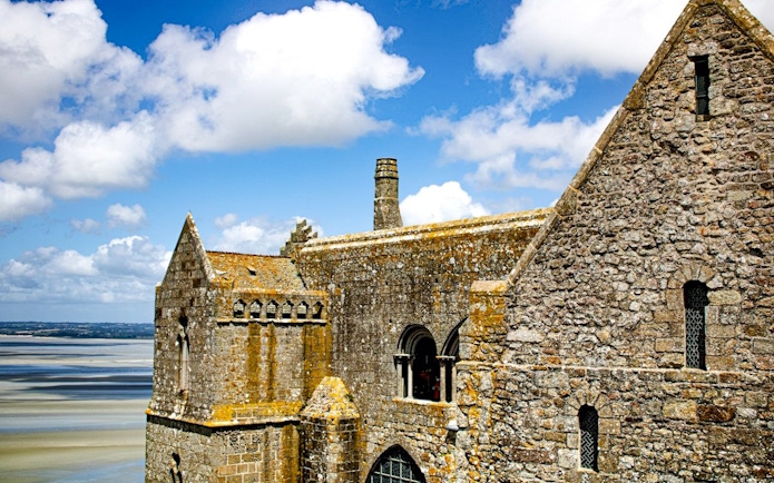 Mont-Saint-Michel Abbey stone architecture with coastal view in Normandy, France.