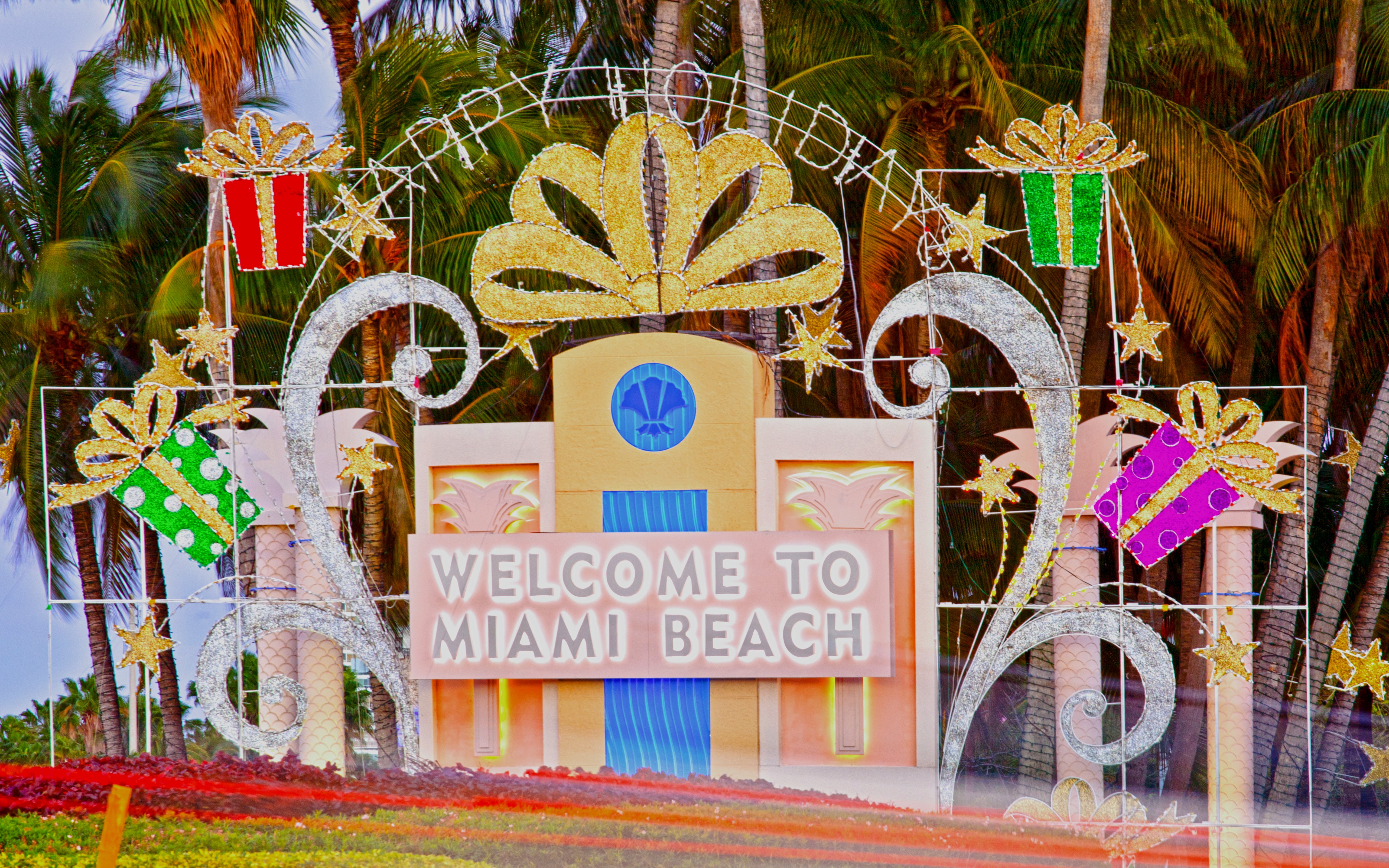 Welcome sign at Miami Beach with Christmas decorations and palm trees.