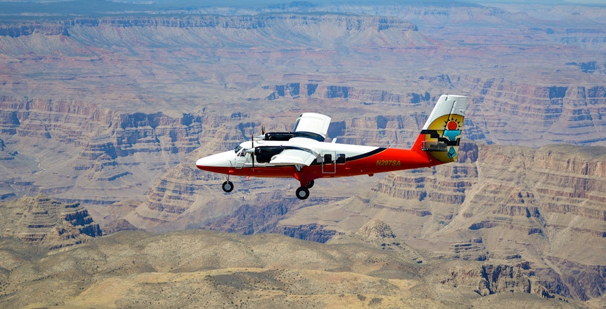 Plane flying over Grand Canyon South Rim, showcasing vast canyon landscape, Las Vegas airplane tour.