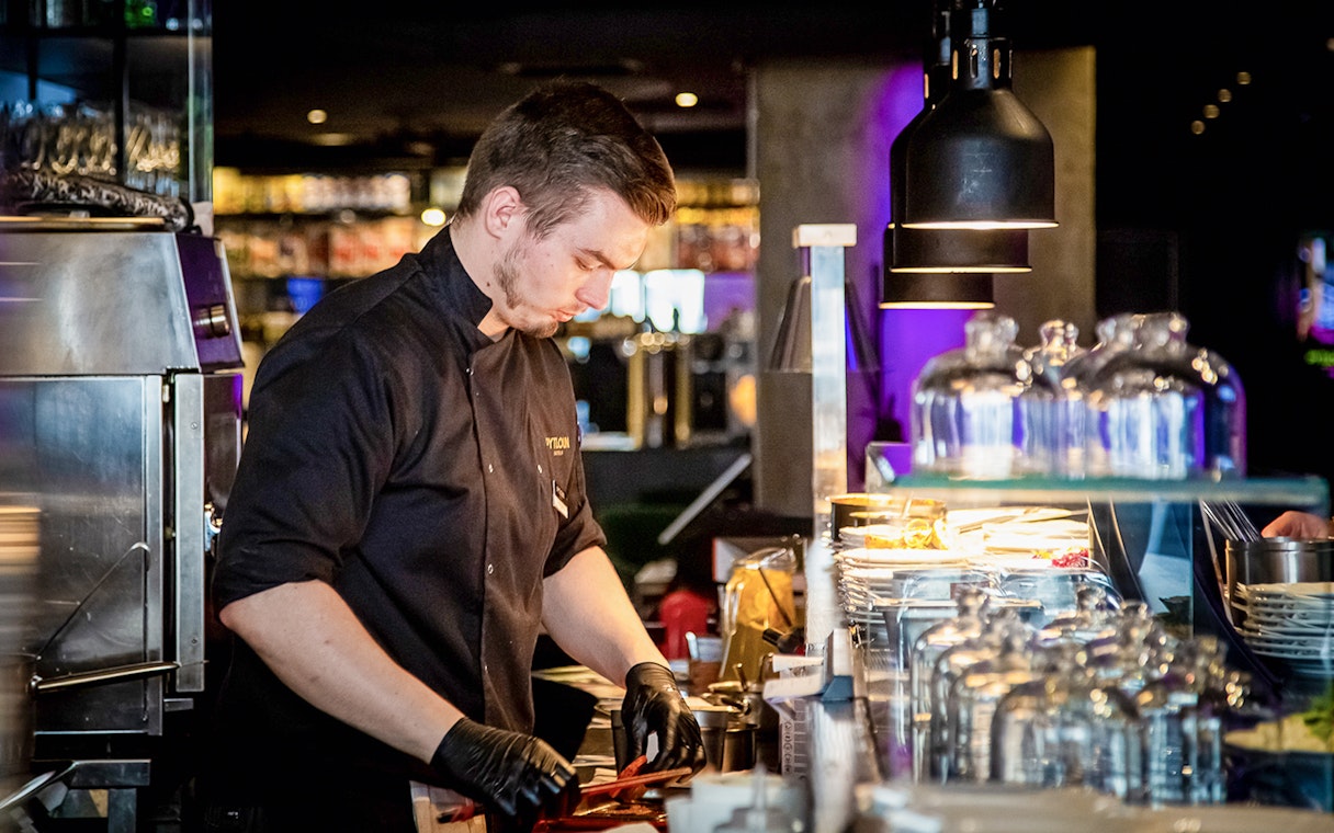 Chef preparing dishes during Czech tapas cuisine tasting tour.