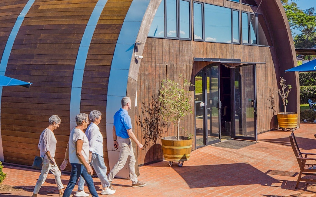 Visitors entering a winery building on Sunshine Coast Hinterland food and wine tour.