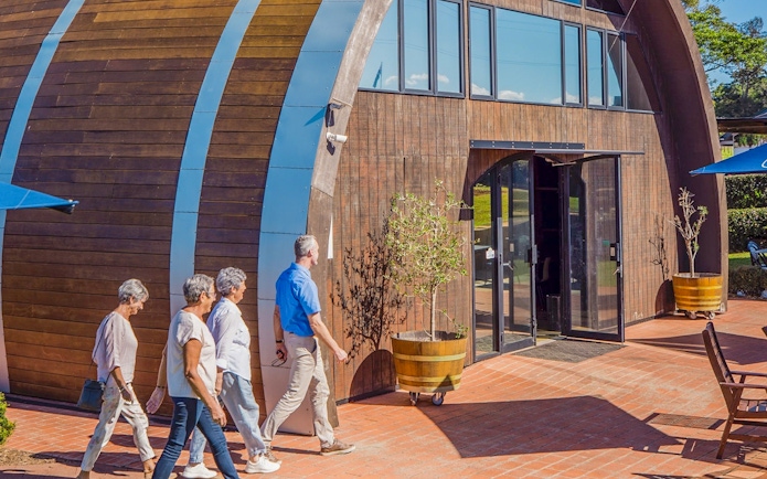 Visitors entering a winery building on Sunshine Coast Hinterland food and wine tour.