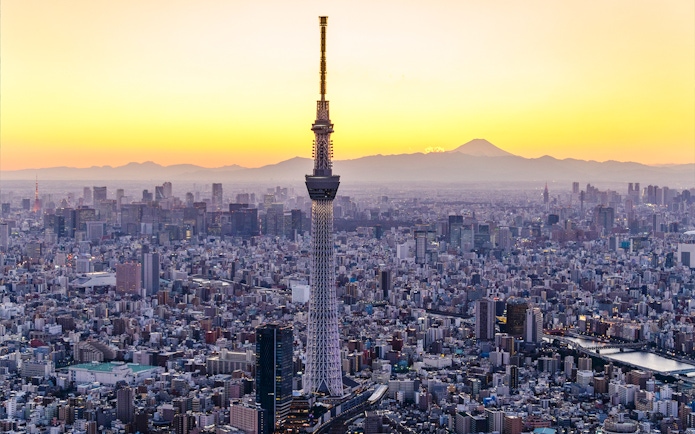 Tokyo Skytree at sunset with cityscape and Mount Fuji in the background.