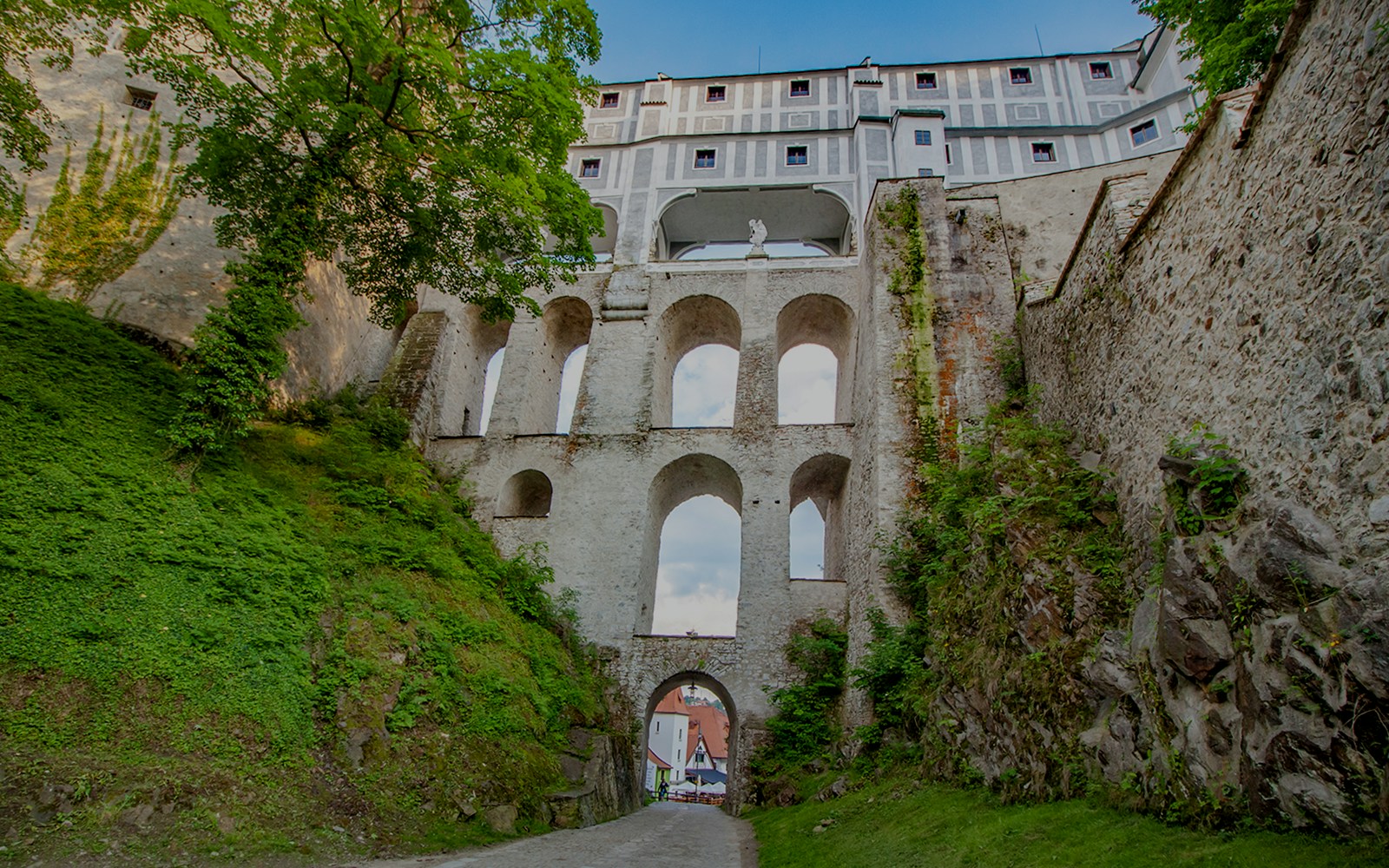 Bridge over Cesky Krumlov Castle with tourists exploring the historic architecture in the Czech Republic.