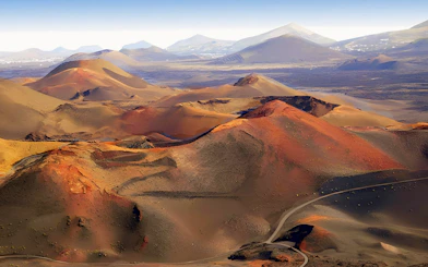 Volcanic landscape of Timanfaya National Park with red and brown craters in Lanzarote.