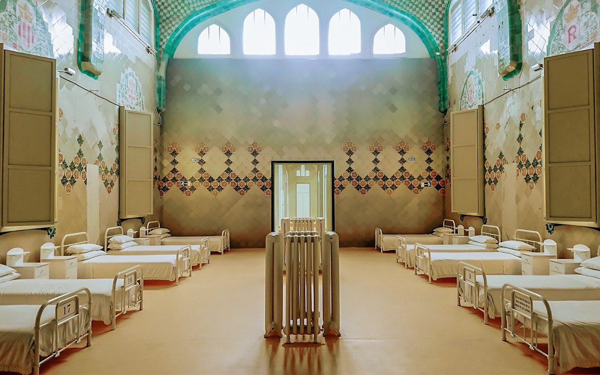 Hospital ward interior at Sant Pau Art Nouveau site, Barcelona, featuring ornate tile designs.