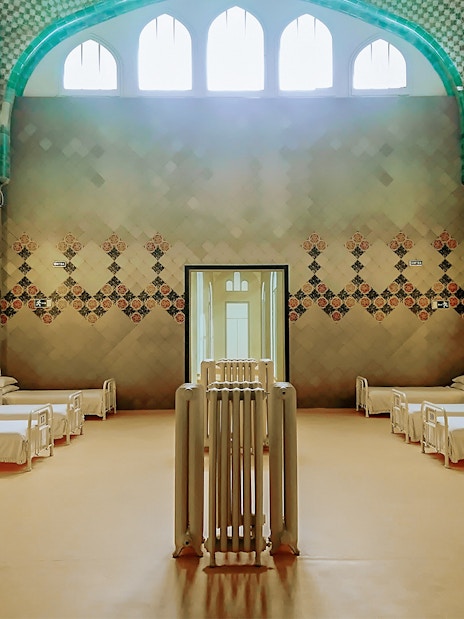 Hospital ward interior at Sant Pau Art Nouveau site, Barcelona, featuring ornate tile designs.