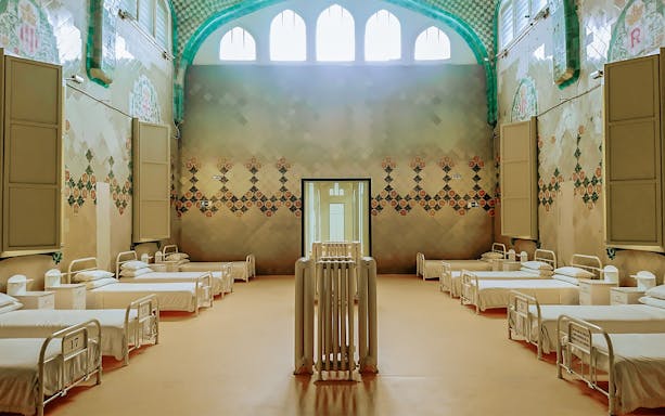 Hospital ward interior at Sant Pau Art Nouveau site, Barcelona, featuring ornate tile designs.