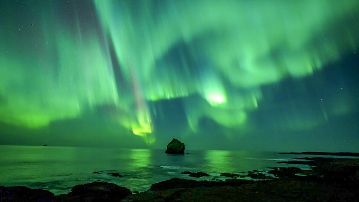 Northern lights over ocean during Premium Northern Lights Super Jeep Tour.