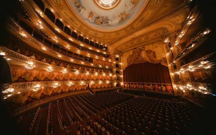 Hungarian State Opera House interior with ornate balconies and stage curtain.