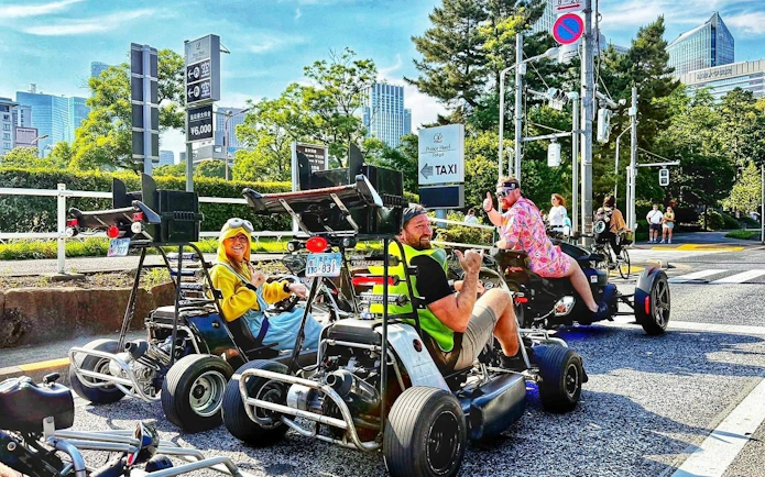 Tourists in costumes driving go-karts on a Tokyo street during a Tokyo Tower Go-Kart Tour.
