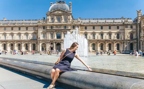 Girl sitting by Louvre Museum fountain in Paris, ideal spot for day trip tour.