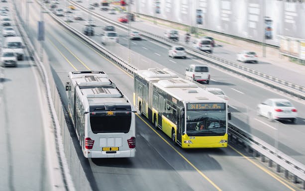 Public buses on a highway, part of unlimited transportation card service with hotel delivery.