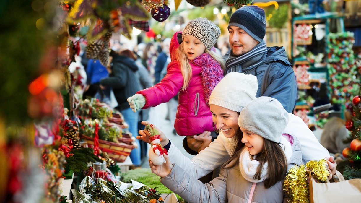 Family exploring Christmas market stalls in Lisbon.