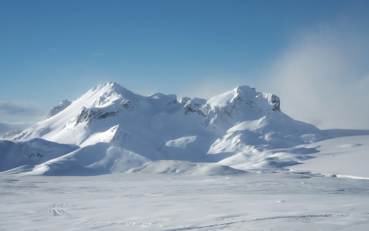 Langjökull Glacier's snow-covered peaks under a clear blue sky in Iceland.