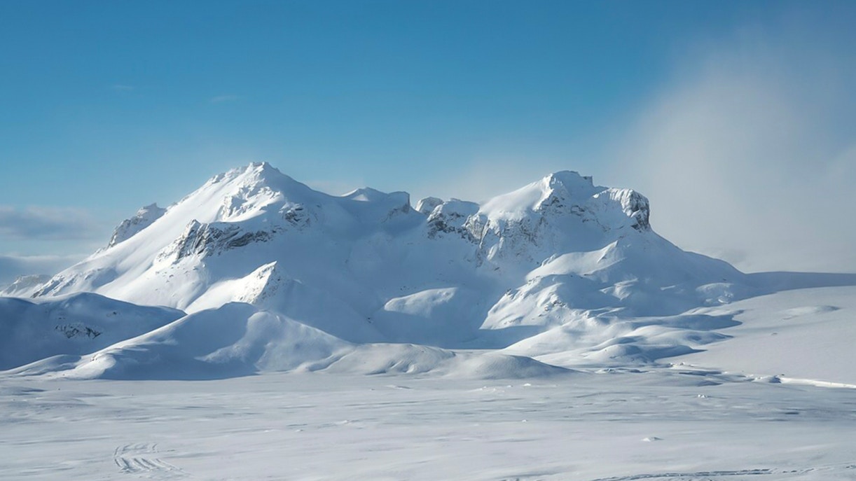 Langjökull Glacier's snow-covered peaks under a clear blue sky in Iceland.