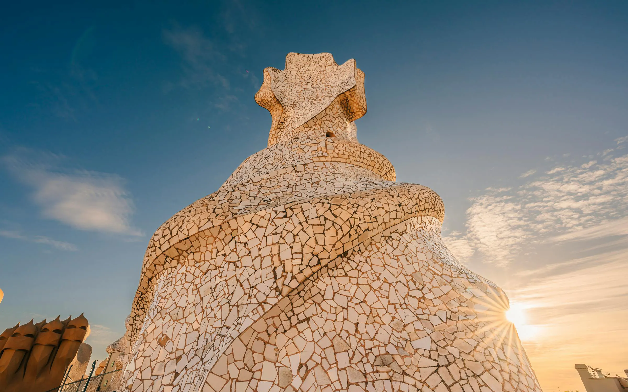 La Pedrera rooftop chimney with mosaic tiles at sunset, Barcelona.