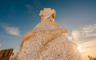 La Pedrera rooftop chimney with mosaic tiles at sunset, Barcelona.