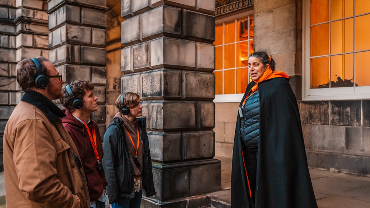 Tour guide leading an evening group in Edinburgh Old Town.