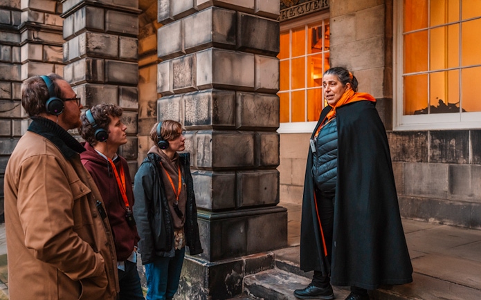Tour guide leading an evening group in Edinburgh Old Town.