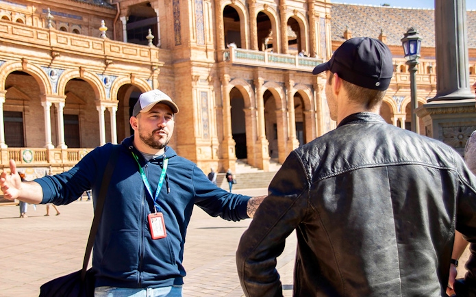 Tour guide explaining Plaza de España architecture during Seville walking tour.