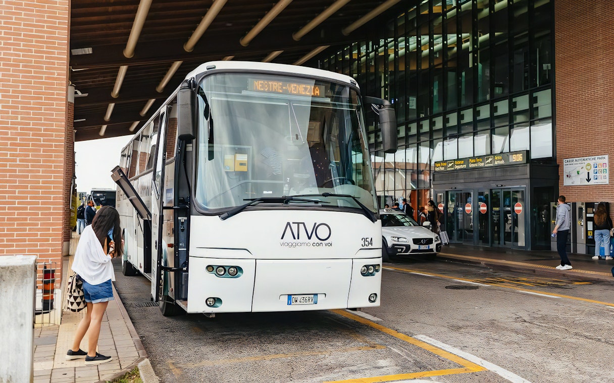 Bus at Venice airport terminal for passenger transfer.