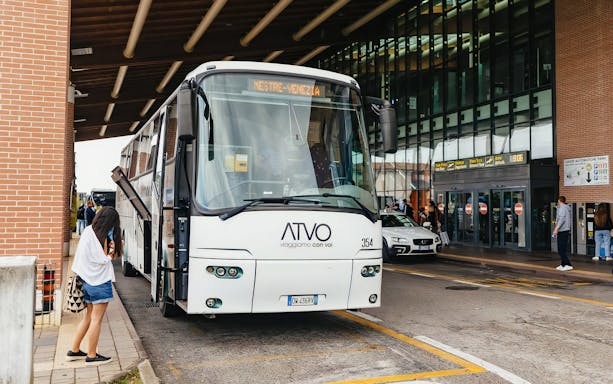 Bus at Venice airport terminal for passenger transfer.