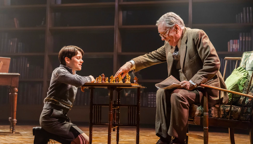 Child and elderly man playing chess on stage during Shadowlands performance, Westend.