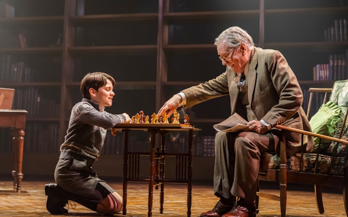 Child and elderly man playing chess on stage during Shadowlands performance, Westend.
