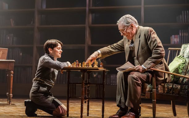 Child and elderly man playing chess on stage during Shadowlands performance, Westend.