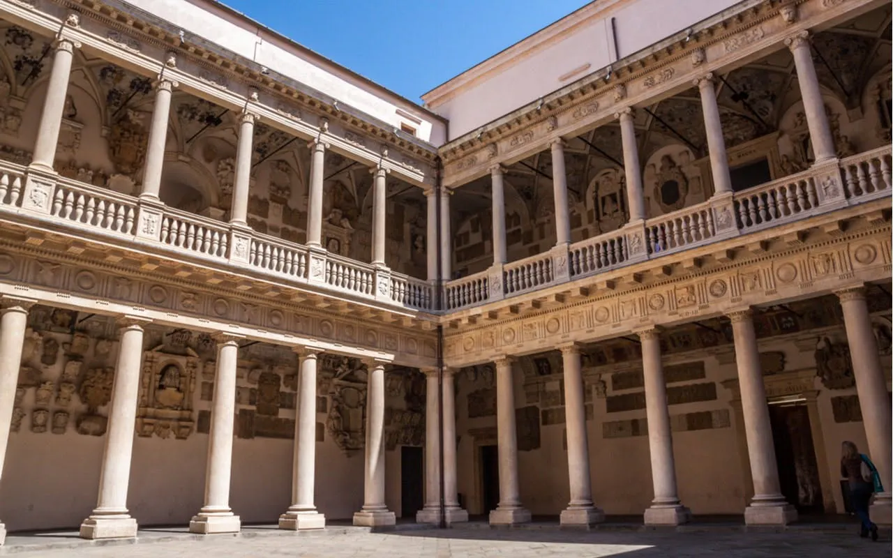 Courtyard of Palazzo Bo in Padua, Italy, featuring ornate columns and historical architecture.