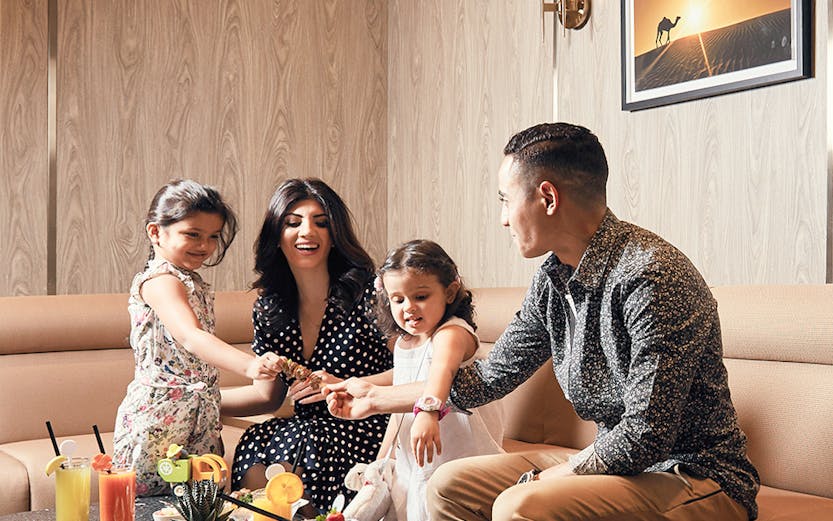 Family enjoying a meal at Plaza Premium Lounge Dubai.