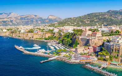 Cetara harbor on the Amalfi Coast with boats docked and colorful buildings on cliffs.