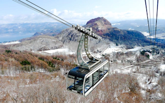 Cable car over snowy landscape with Lake Toya and Mount Usu in Hokkaido, Japan.