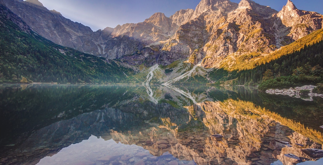Morskie Oko Lake reflecting Tatra Mountains, Poland, near Slovakia Treetop.