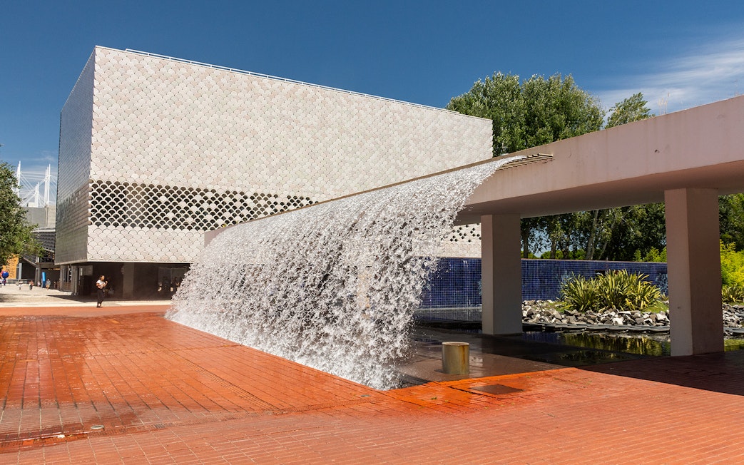 Lisbon's Parque das Nações with modern architecture and waterfall feature.