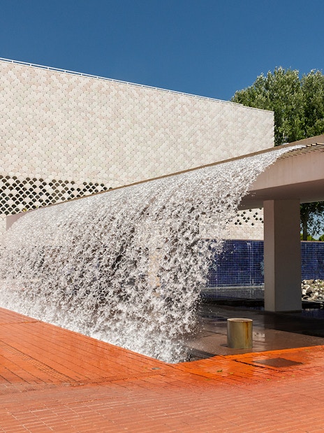 Lisbon's Parque das Nações with modern architecture and waterfall feature.