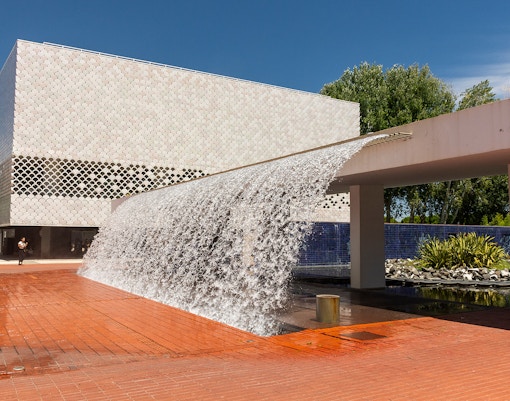 Lisbon's Parque das Nações with modern architecture and waterfall feature.