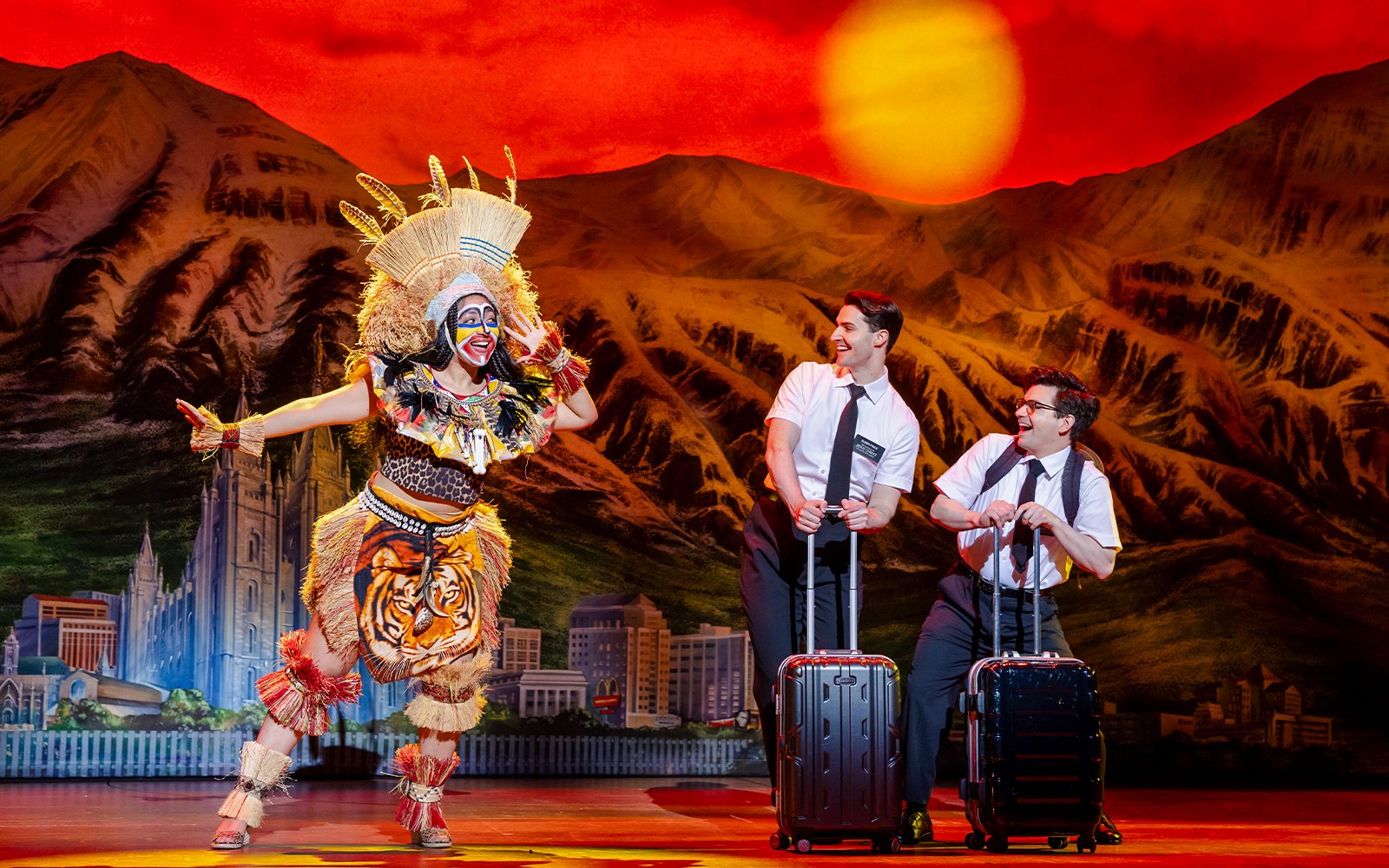 Stage performance of The Book of Mormon in Brisbane with actors in colorful costumes.