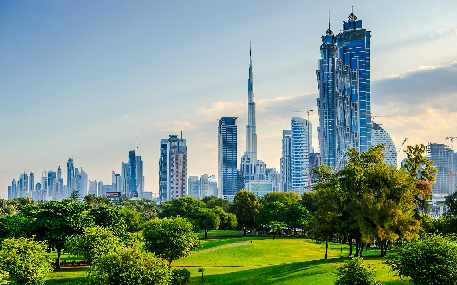 Skyline view from Burj Park, Dubai with Burj Khalifa and lush greenery.
