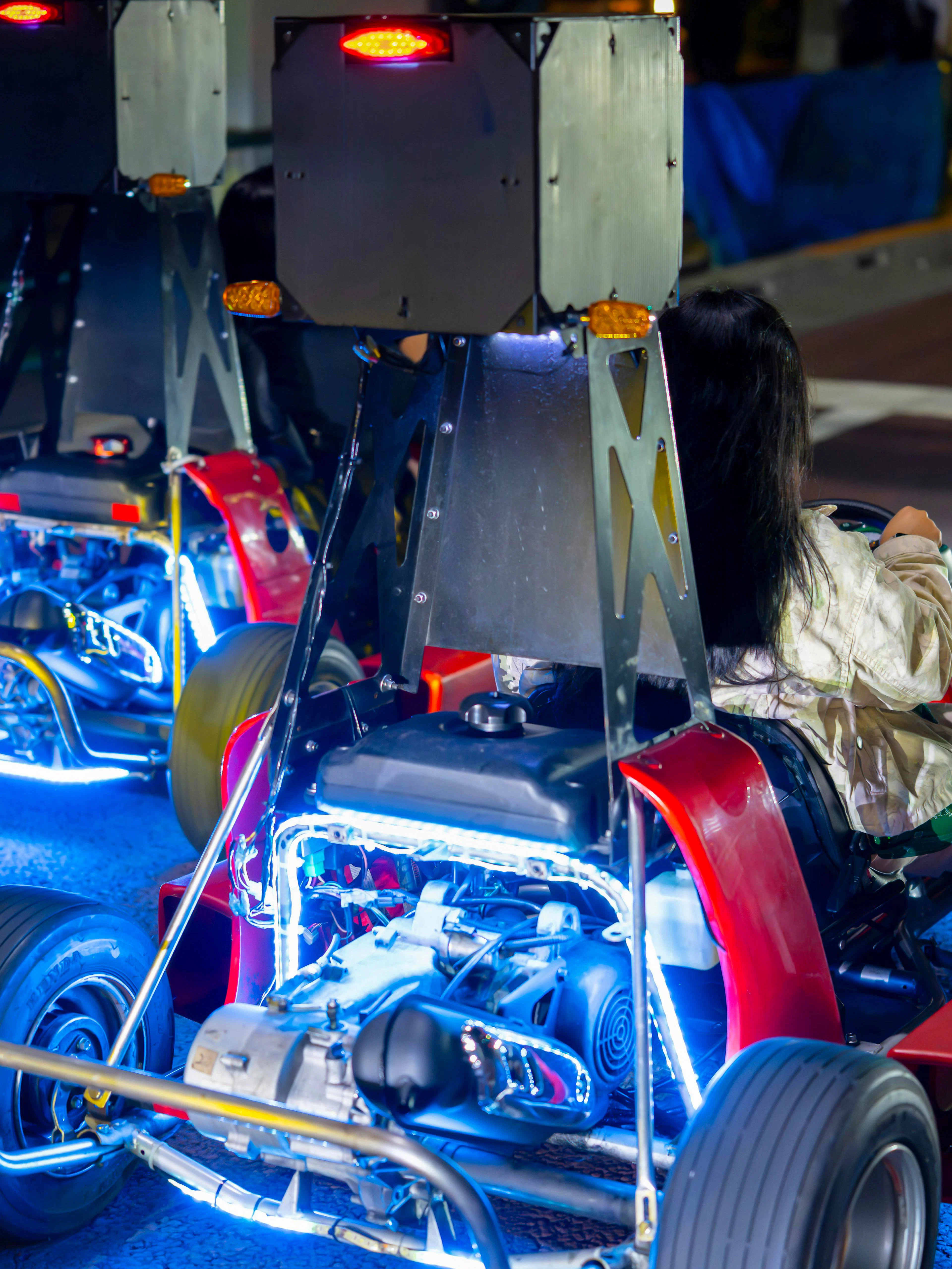 Go-karts driving on a Tokyo street at night with neon lights.
