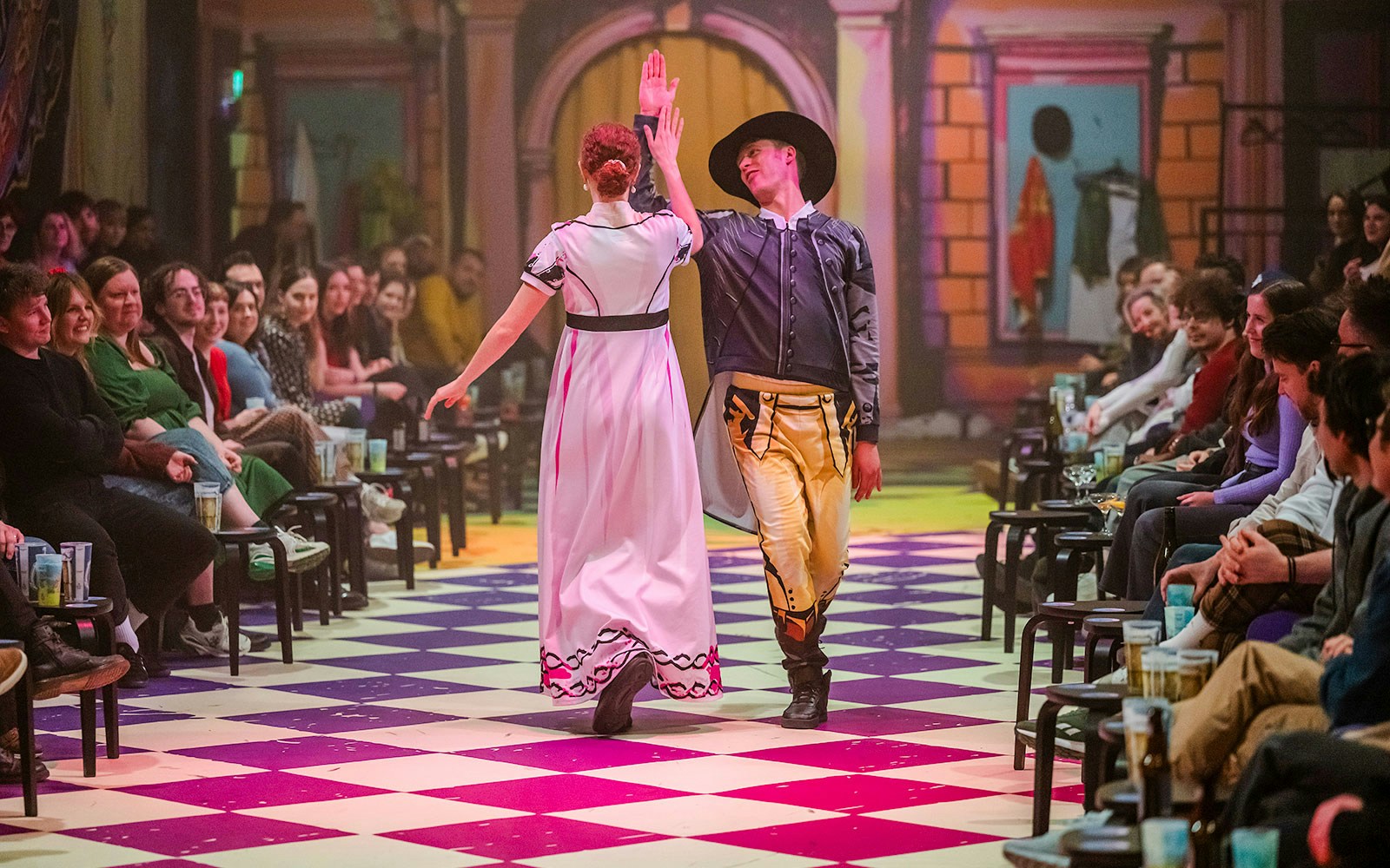 Dancers performing in a theater setting for "Plied and Prejudice" with audience watching.