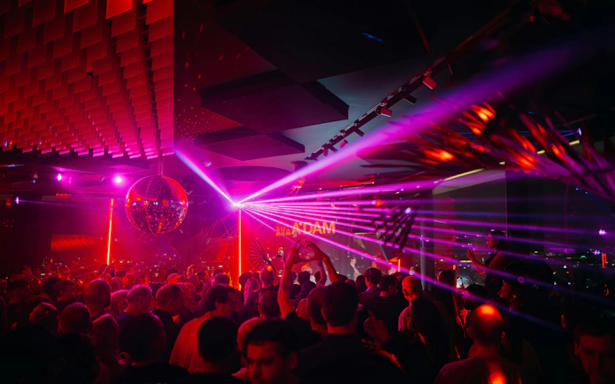 Crowd enjoying nightlife with laser lights at A'DAM Tower Skybar, Amsterdam.