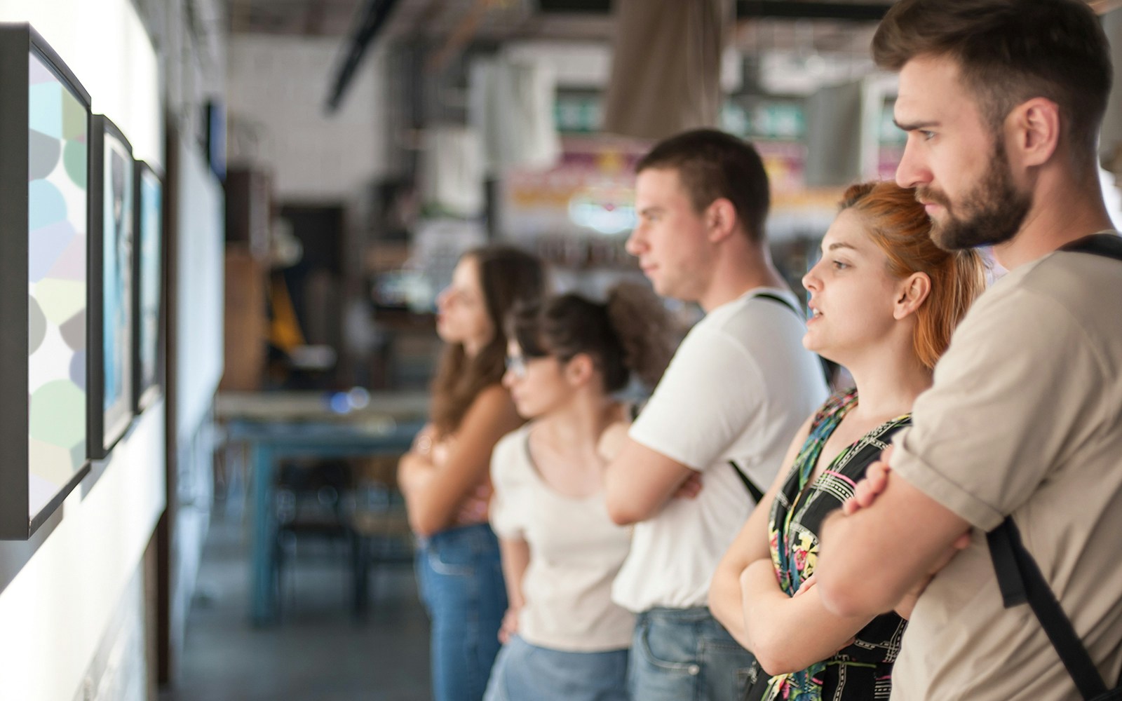 Visitors observing artwork in a modern art gallery.
